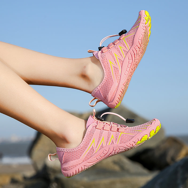 pink and yellow water shoes with beach in background